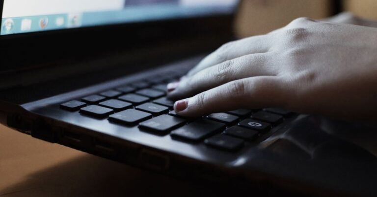 Maos digitando a senha em um notebook
