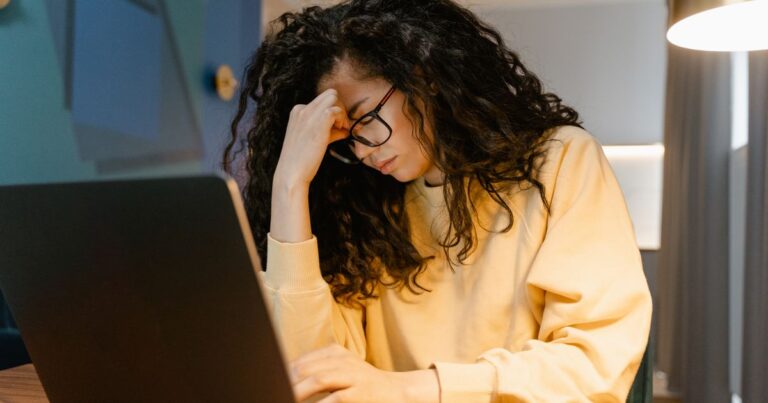 Mulher preocupada tentando recuperar a conta no computador