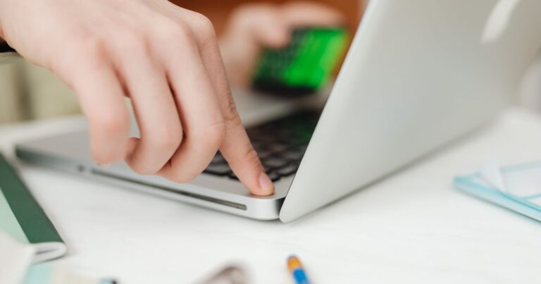 Maos operando um notebook com protecao de seguranca