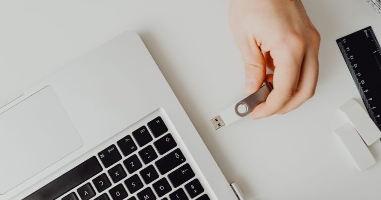 Pessoa conectando um pendrive ao notebook para fazer backup