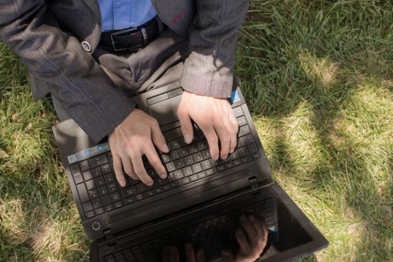 Maos digitando em um notebook para criar uma conta de e-mail