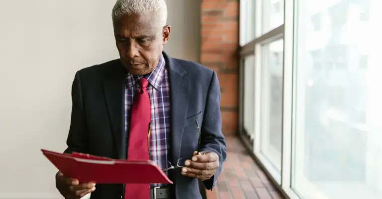 Homem idoso lendo documento de proposta