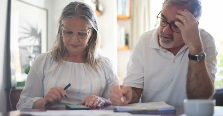 Casal idoso fazendo contas em casa