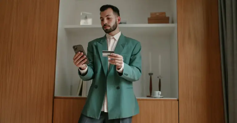 Homem consultando cartão e celular