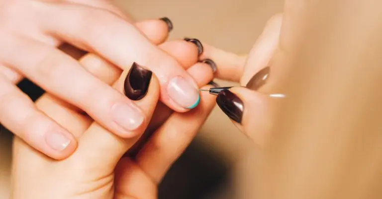 Manicure profissional aplicando esmalte na cliente durante o atendimento