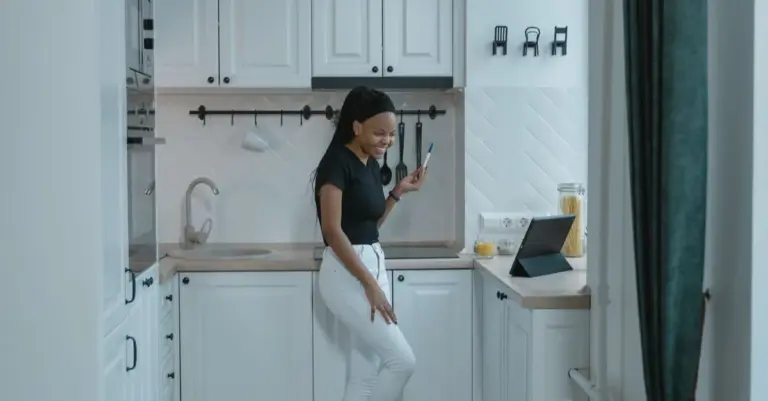 Dona de casa resolvendo as finanças da família pelo celular na cozinha