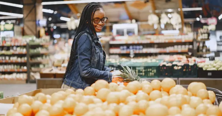 Mulher sorrindo fazendo compras no mercado