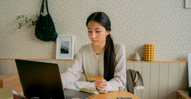 Mulher comprando online com cartão no notebook