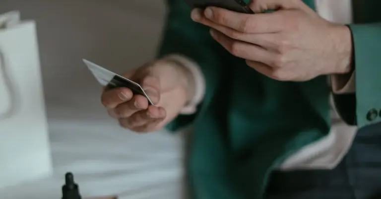 Mãos com cartão de crédito e celular nas compras