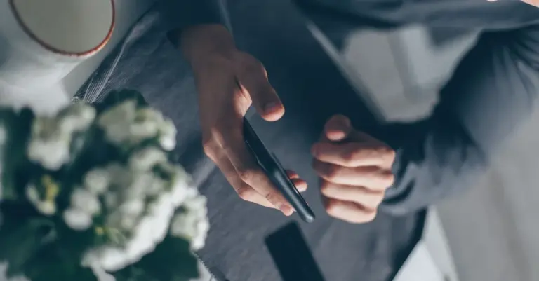 Mãos usando o aplicativo no celular