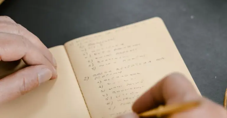Pessoa concentrada a escrever anotações num caderno, ilustrando a preparação de uma checklist antes de pedir um cartão de crédito