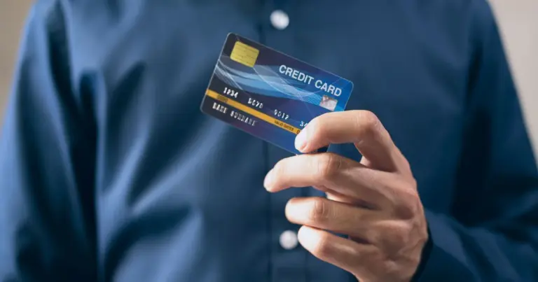 Pessoa de camisa azul a segurar um cartão de crédito