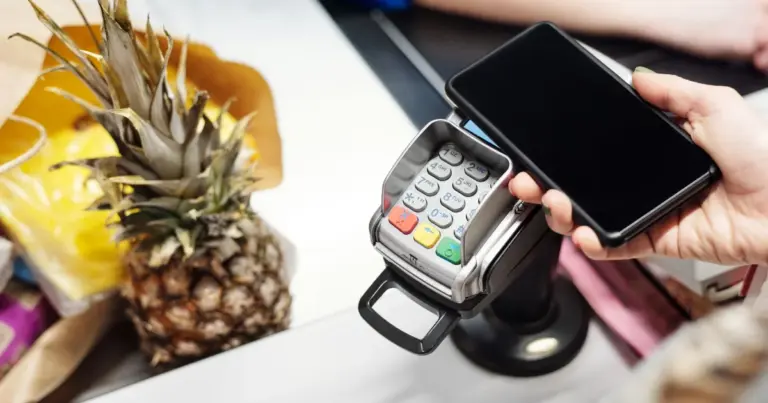 Pessoa a fazer pagamento sem contacto com o telemóvel durante uma viagem