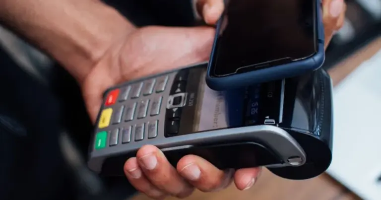 Telemóvel a ser usado para pagamento sem contacto num terminal de pagamento