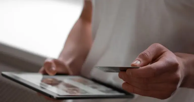 Pessoa a segurar um tablet e um cartão em casa