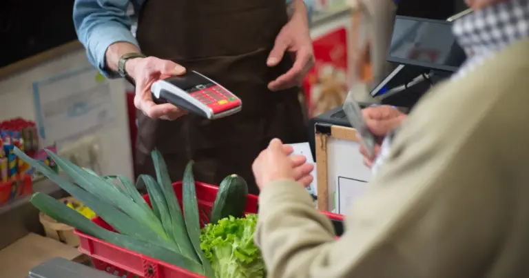 Cliente a pagar com cartão de crédito ao balcão de uma mercearia