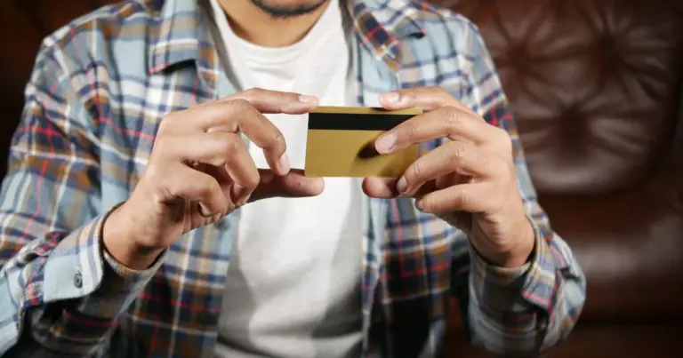 Homem a segurar um cartao dourado com as duas maos