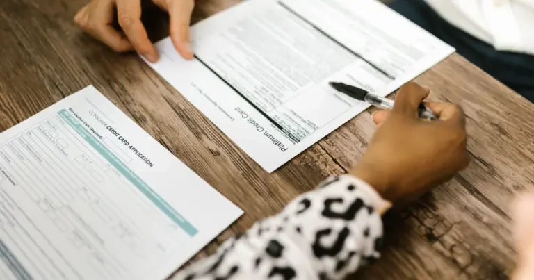 Duas pessoas a rever e assinar um pedido de cartao de credito