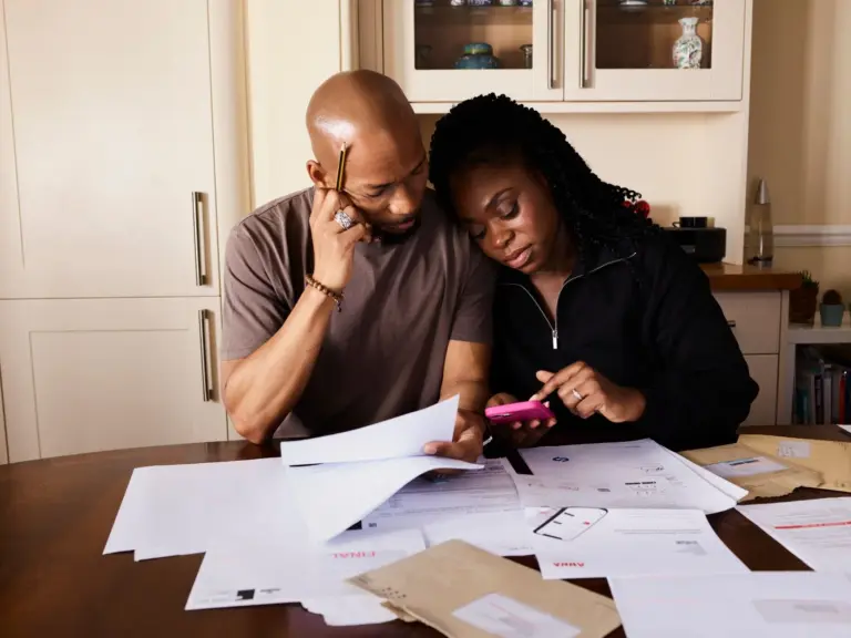 Casal português a analisar documentos financeiros e RSI em casa
