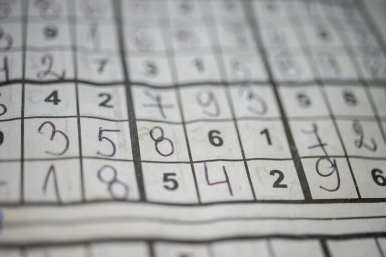 Grade de Sudoku em papel com números impressos e anotações a lápis.